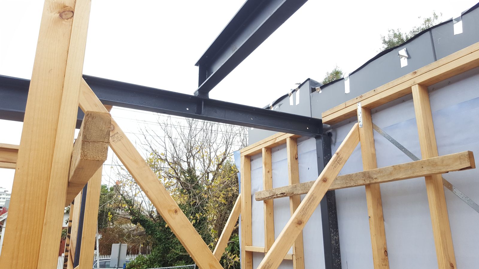 Structural steel beams meeting timber wall frames