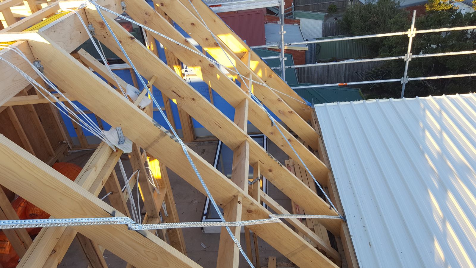 Roof framing with bracing straps and the first roof panels