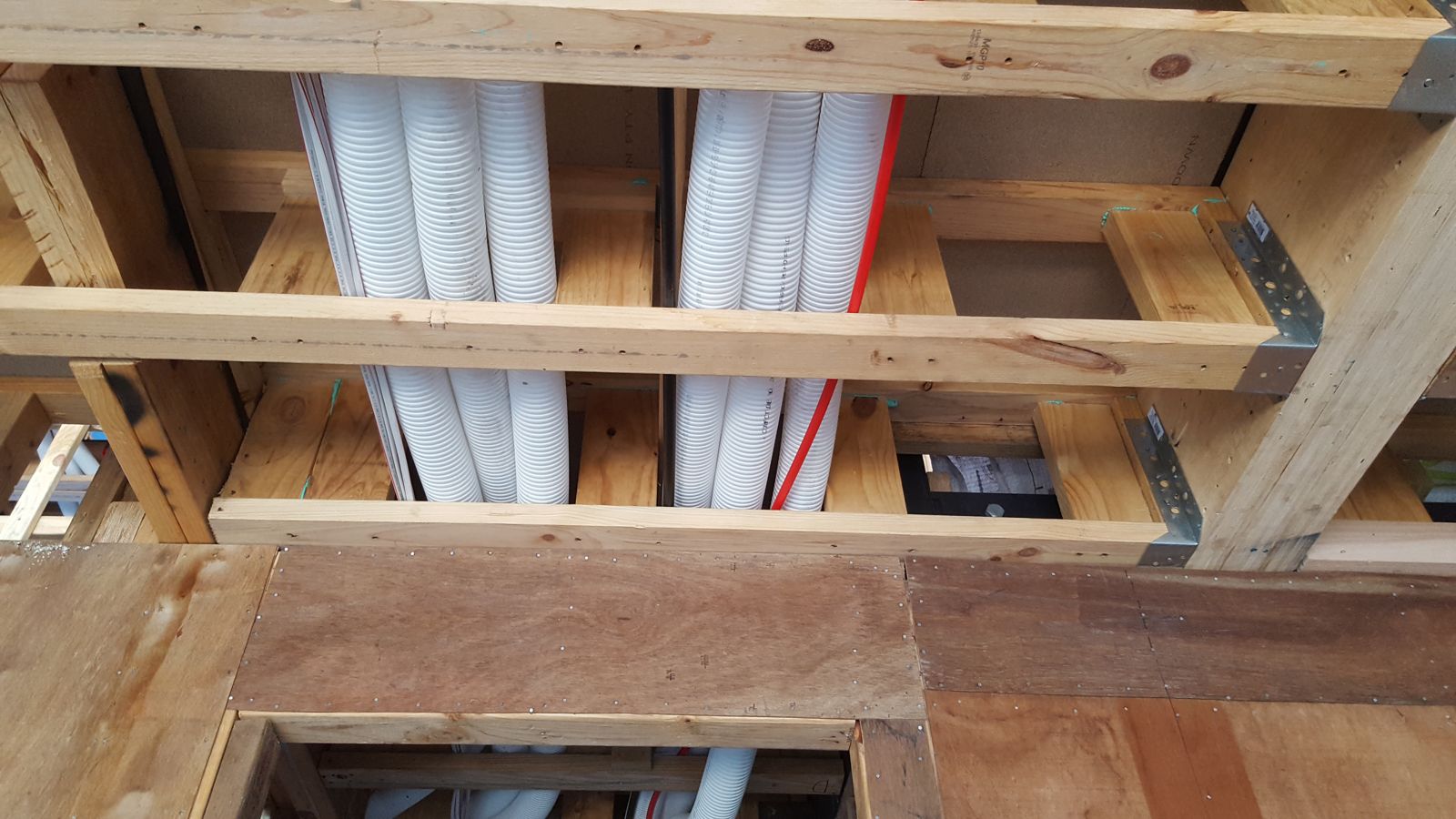 Ventilation ducts running through the floor framing