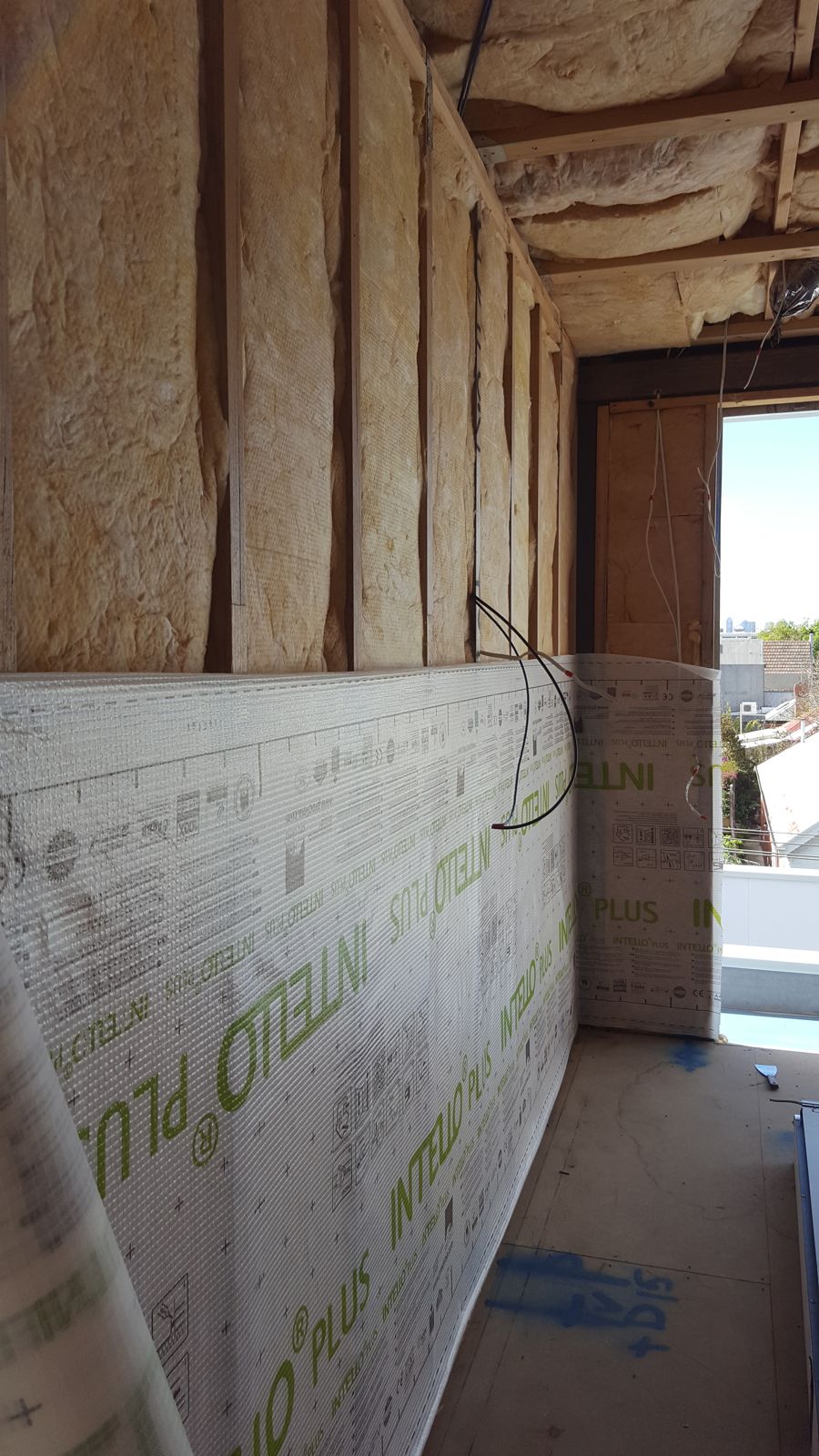 Wall insulation batts fitted between studs, with the membrane going on below