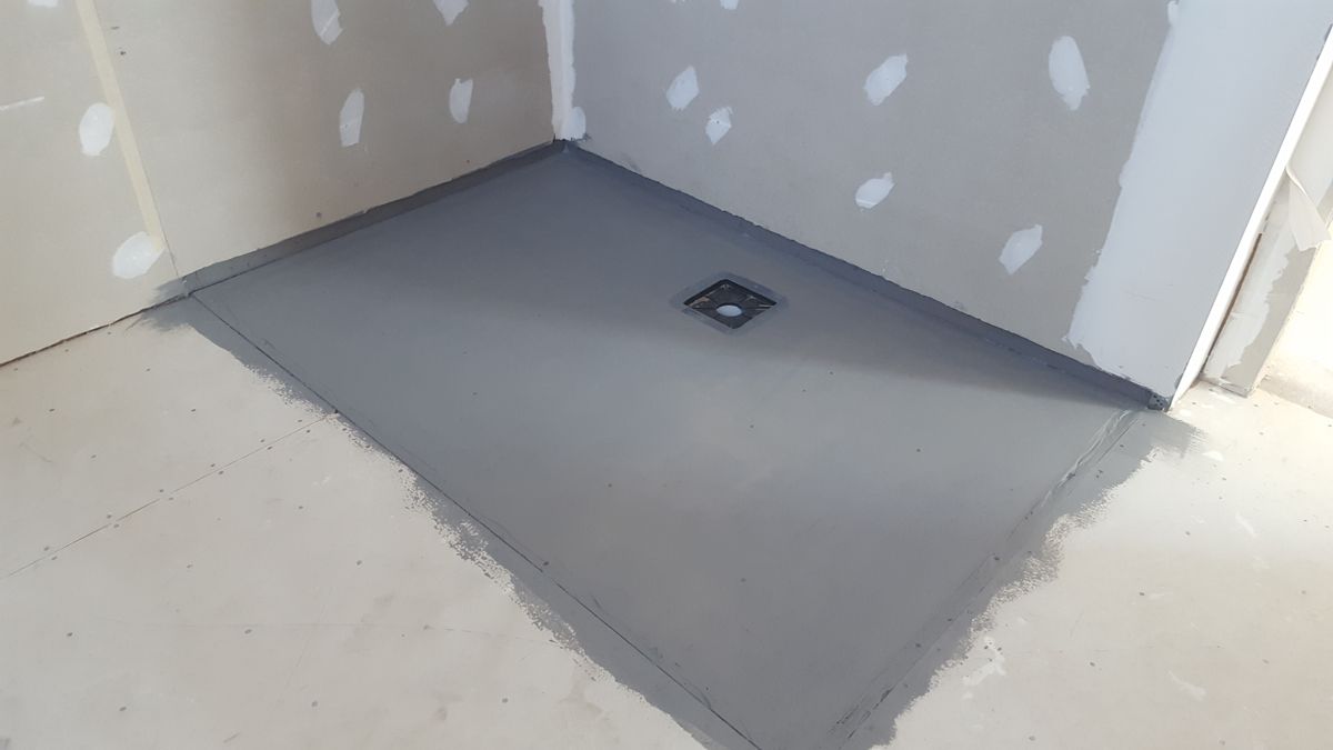 Shower wet-area substrate with the waste sealed, before tiling