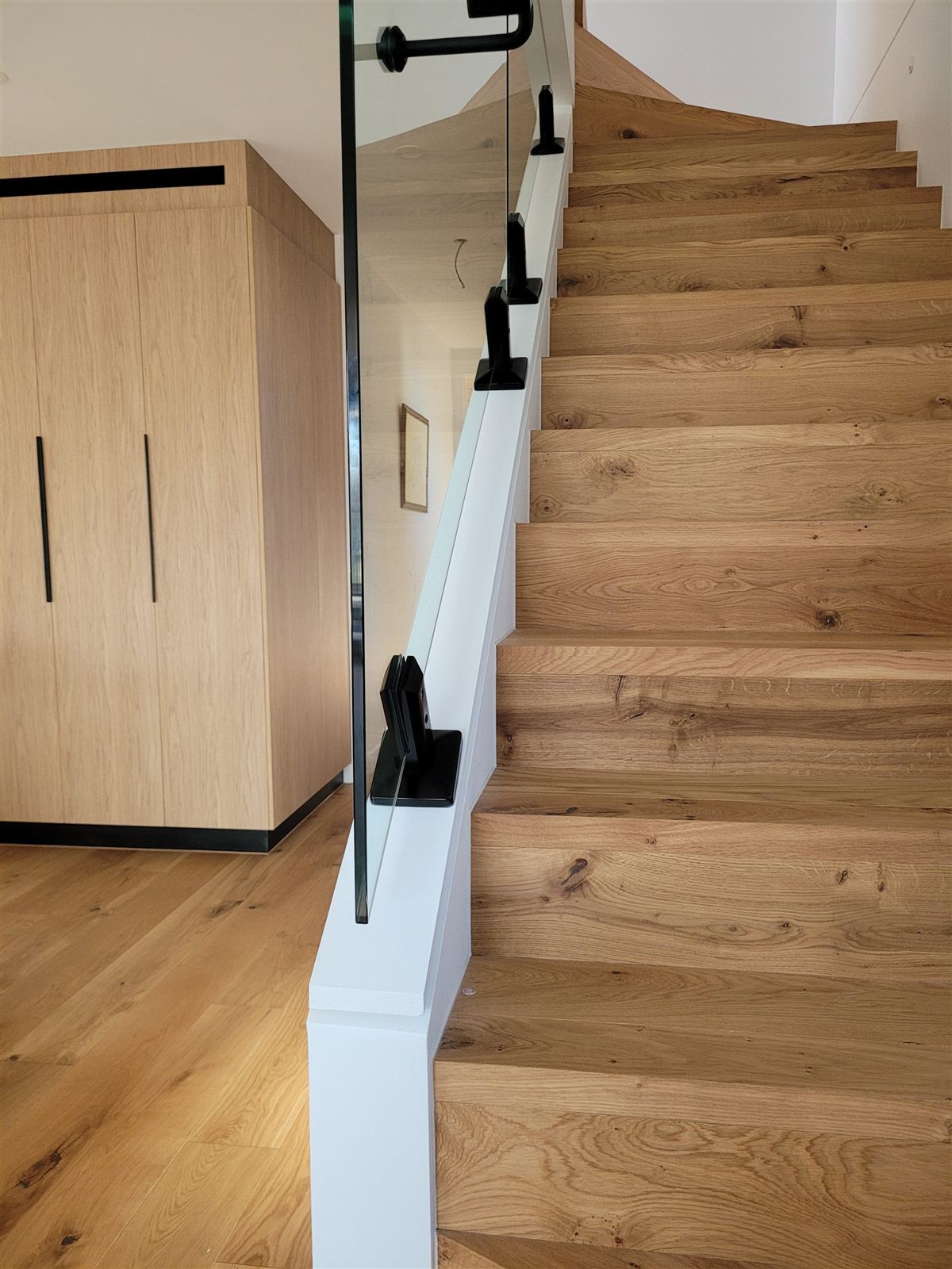 Timber staircase with glass balustrade in a St Kilda home designed by Mancini Design